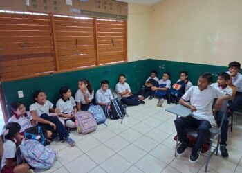 Estudian niños en el piso, en Solferino