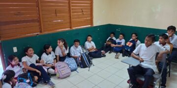 Estudian niños en el piso, en Solferino