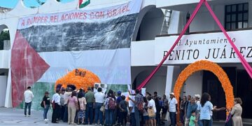 ¡Protesta internacional!; cuelgan activistas lona con bandera de Palestina en el Palacio Municipal de Cancún