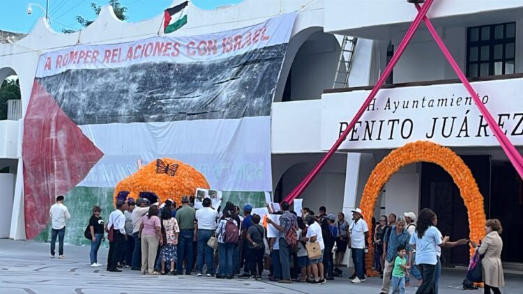 ¡Protesta internacional!; cuelgan activistas lona con bandera de Palestina en el Palacio Municipal de Cancún